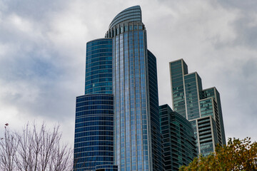 Obraz premium City architecture. Modern glass building. Reflective glass architecture. Architecture in business district. Building architecture. Business building. Glass building. Business city