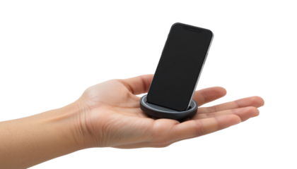 Hand holding black smartphone in round charging dock, isolated on transparency background, modern technology concept