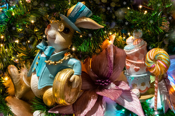 Christmas tree with a Wonderland bunny and marshmallow candy decorations, selective focus. Christmas cute decoration for a children's party
