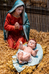 Figurines of Mary and Jesus in a decorative nativity scene, selective focus 