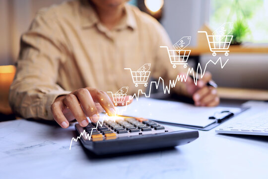 incoming concept with entrepreneur on working table is using calculator to summary cost and profit shopping cart grow up in total sale for online business