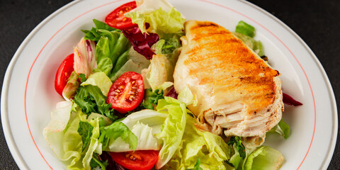Grilled chicken breast salad chicken breast tomato, green leaf lettuce, salad mix snack vegetables snack gourmet food background on the table rusticcopy space keto and paleo diet vegan and vegan food