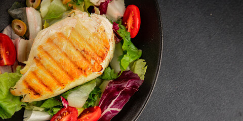 Grilled chicken breast salad chicken breast tomato, green leaf lettuce, salad mix snack vegetables snack gourmet food background on the table rusticcopy space keto and paleo diet vegan and vegan food
