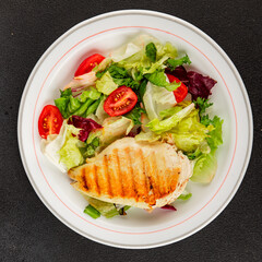 Grilled chicken breast salad chicken breast tomato, green leaf lettuce, salad mix snack vegetables snack gourmet food background on the table rusticcopy space keto and paleo diet vegan and vegan food