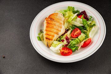 Grilled chicken breast salad chicken breast tomato, green leaf lettuce, salad mix snack vegetables snack gourmet food background on the table rusticcopy space keto and paleo diet vegan and vegan food