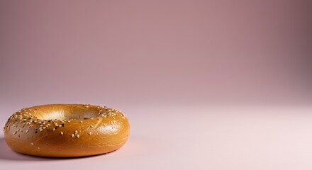 Bagel with sesame seeds on a plain pink background isolated with space for text or design elements