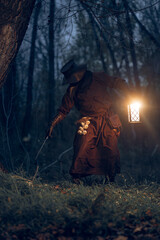 Mysterious figure explores a dark forest with lantern and foraging tools.