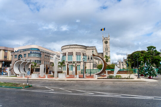 Bridgetown, Barbados: Monument to the Barbadian Family in Heroes Square (formerly Trafalgar Square) with the Parliament Buildings and Bajan flag in heart of the capital. 