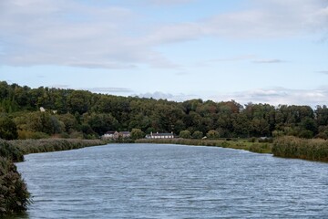 View of the River Arun meandering though the west Sussex countryside with The Black Rabbit Pub in the background
