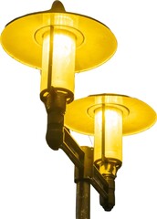 Vintage street lamp illuminating a pathway in an urban setting during the evening hours