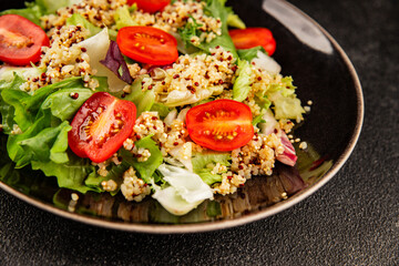 Quinoa salad tomato, green leaf salad vegetables dish natural tasty snack fresh delicious gourmet food background on the table rustic top view copy space keto and paleo diet vegan and vegan food