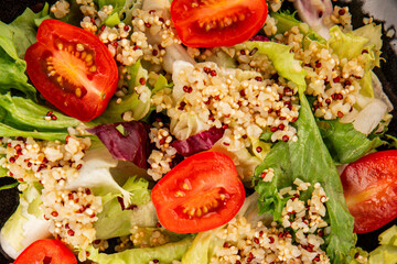 Quinoa salad tomato, green leaf salad vegetables dish natural tasty snack fresh delicious gourmet food background on the table rustic top view copy space keto and paleo diet vegan and vegan food