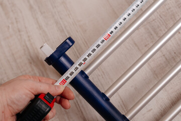 Hand measuring wardrobe sliding pants rack with tape measure