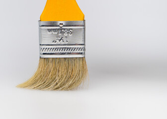 Yellow paintbrush close up on gray background