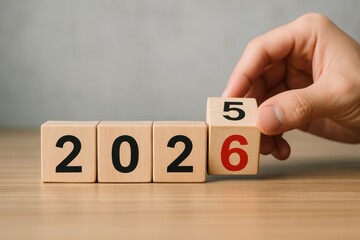 Wooden blocks forming year 2026 with hand flipping last digit from 5 to 6 on wooden table surface, symbolizing new year transition concept. Ai generative