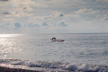 Young boy dives into the sea from the puddle board. Fun