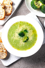 Warm and comforting creamy broccoli soup served in a bowl, garnished with parmesan cheese and croutons.