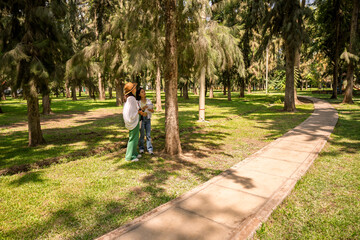 Obraz premium Female students doing botanical fieldwork in city park forest