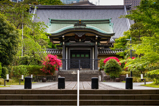 traditional japanese entrance of a temple decorated with plants and flowers