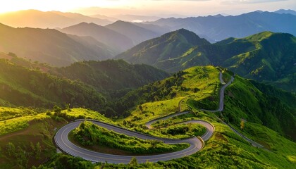Scenic mountain road winding through lush green hills at sunrise