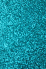 Abstract vertical blurred shiny turquoise glitter texture background
