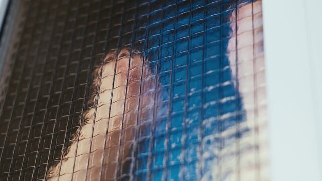 A close-up of a prisoner banging his fist on the window of a pre-trial detention cell