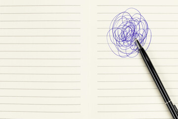 Concept of stress, confusion, or brainstorming with a pen making a chaotic scribble on a lined notebook.