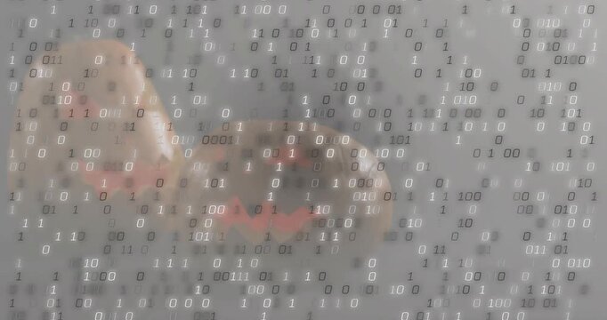 Two carved pumpkins sitting on grey set starting binary digits streaming representing data takeover
