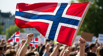 Crowd holding Norwegian flag with fists raised during protest. People demonstrating for national pride or political cause.