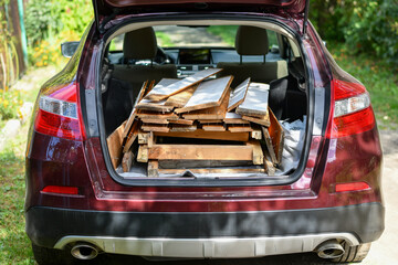 Load of old wooden planks and boards loaded in car to be moved to recycling utility