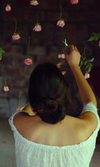 mujer de espaldas cortando rosas