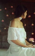 mujer sentada con rosa, de epalda