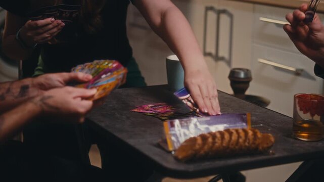 A cozy evening in a modern kitchen where a small group of friends gathers around a round table to play a board game