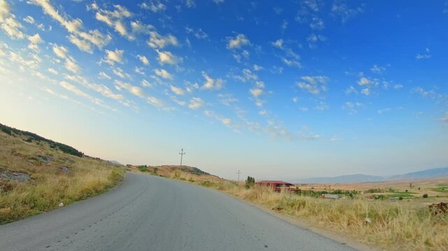 POV driving in the countryside, summer season, dry grass, skyline