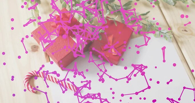 Particles drifting into view starting network over gift boxes and candy cane, creating purple wash