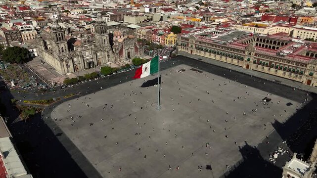 Push-in crane down shot approaching the Mexican flag at Zocalo square in Mexico City, Mexico