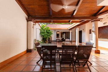 Covered terrace with wooden table and columns in tropical house