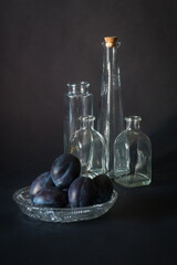 Arrangement with blue purple plums on a background of the same color