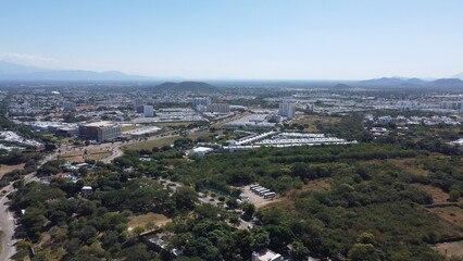 Aerial drone view of valledupar city in Colombia, buildings in background and blue sky.