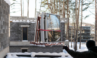 A crane lifts plastic windows at a construction site