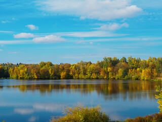 A colorful autumn forest by the lake. Blue skies and sunny weather.