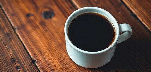Close-up of a stark white mug filled with dark, rich coffee resting on warm, rustic wood,  minimalism,  texture