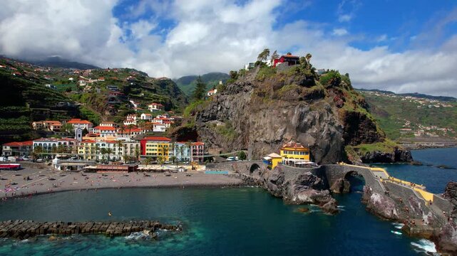 Madeira island scenery - picturesque village Ponta do Sol with impressive rocks,  beach and colorful houses. Portugal travel, scenic places and tourist destination. drone 4k hd footage