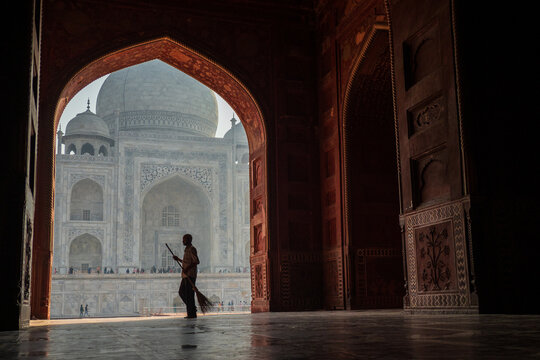 Taj Mahal Framed by Arch with Worker Silhouetted in Agra copy space