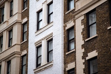 Obraz premium The striking architecture showcases a captivating blend of contrasting brick and pristine white wall designs, set against the vibrant backdrop of an urban landscape during the brightness of daylight