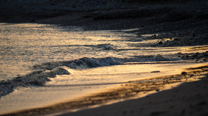 Golden Sunset Reflections on Gentle Waves at Sandy Beach