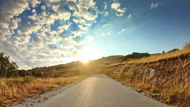 Beautiful summer nature, dry grass, rocky terrain, shining sun, POV drive