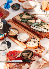 Overhead view of a large table filled with assorted appetizers, cheese, charcuterie and bread, festive dining setup.

