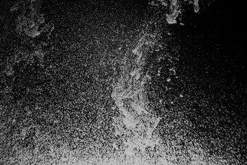 Obraz premium Abstract view of white and blue particles floating against a black background, resembling stars in space or underwater bubbles in darkness.