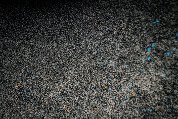 Black and white abstract image resembling snowfall at night or a starry sky, with countless white specks scattered across a dark background.